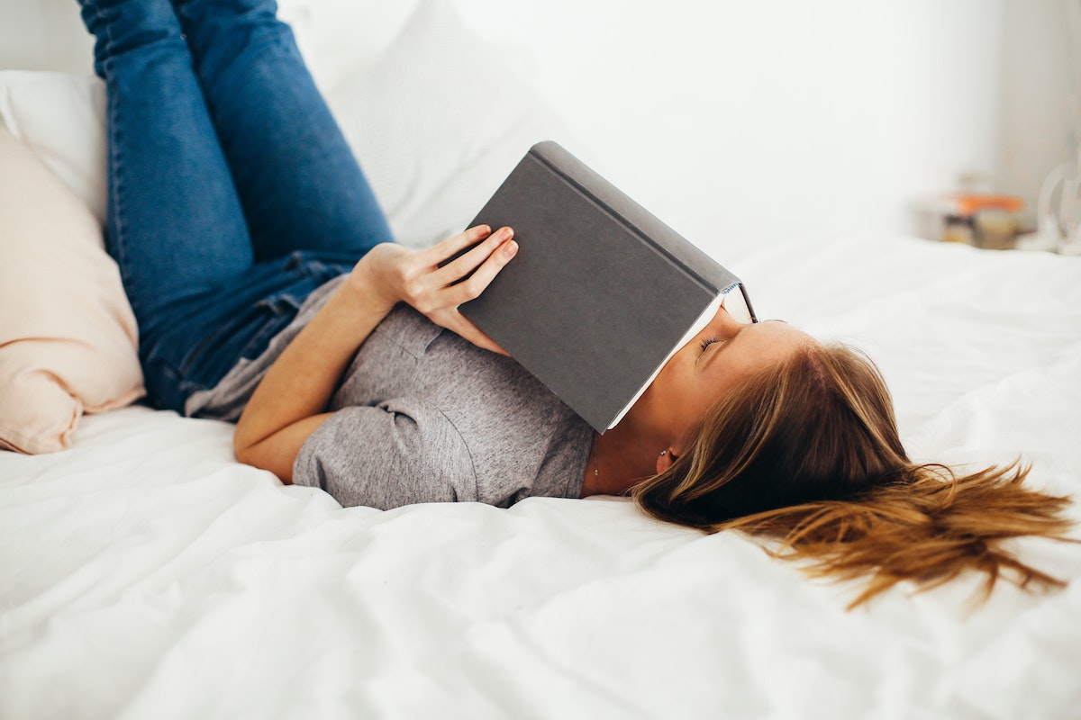 relaxed woman on bed with book