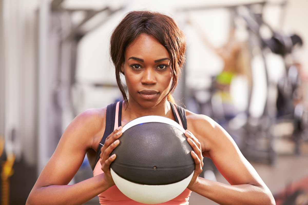 woman holding medicine ball at gym
