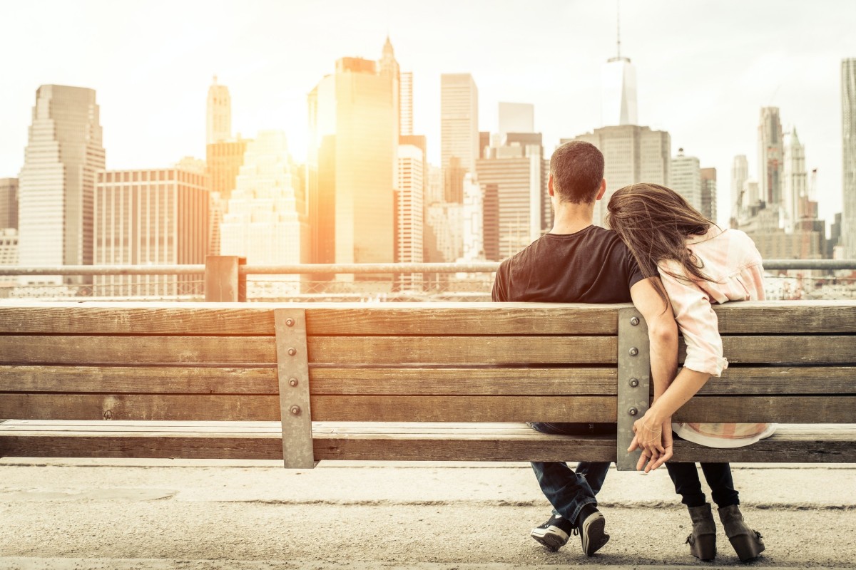 man and woman snuggling on a bench